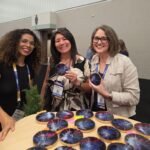 Guest receiving a custom hand-painted coaster at a corporate event