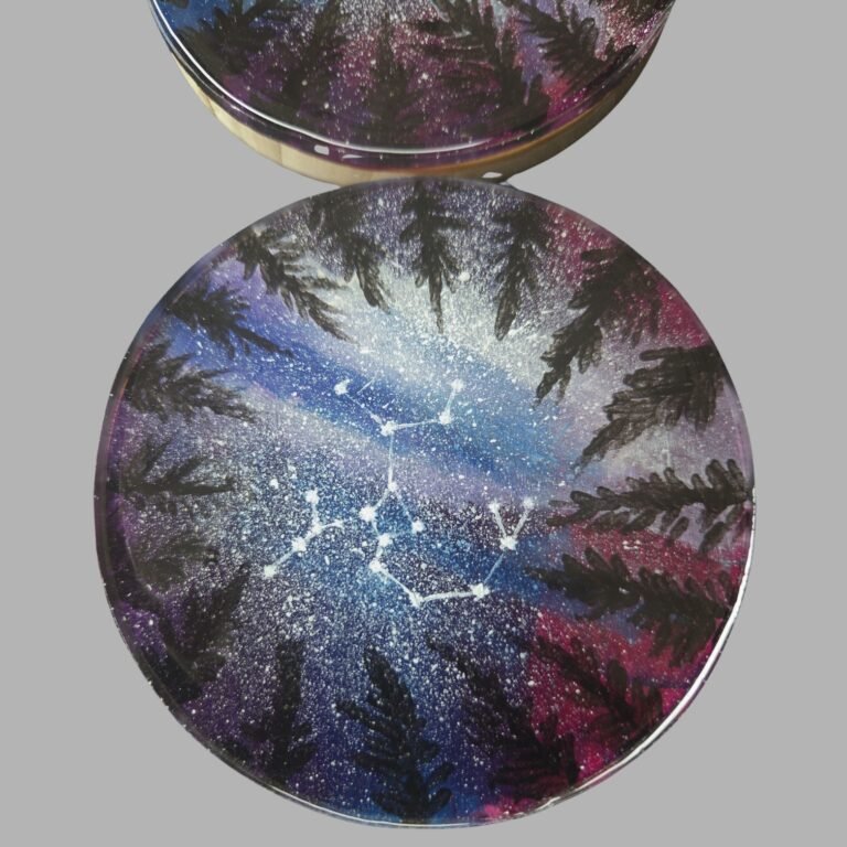 Close-up of a hand-painted coaster with blue purple and pink abstract artwork
