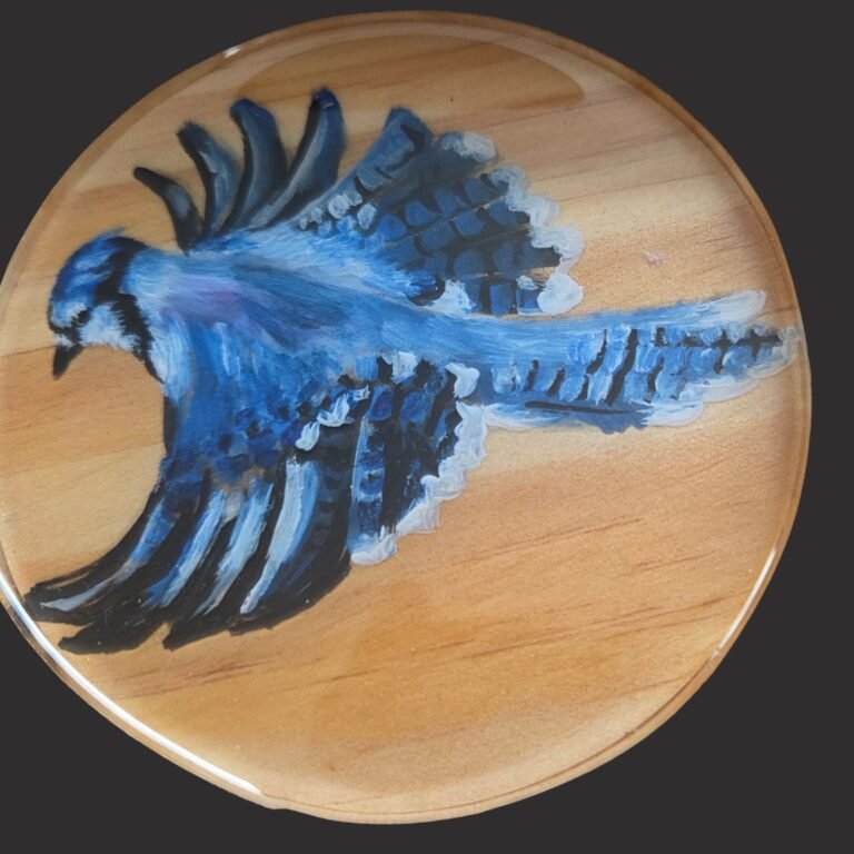 Hand-painted blue bird coaster with detailed wings in flight